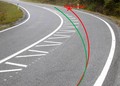 Če motorist pelje po rdeči liniji tako, da ne povozi dodatnih črt, ki ob deževju drsijo, to pokvari idealno in varno linijo ovinka in motorist zapelje s ceste. Zelena linija ovinka je varna, motorist pa kljub temu, da je v ovinku nagnjen, ne sega v nasprotni vozi pas. Tako se vozu 99% motoristov