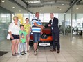 Vodja trženja David Kušanić izroča ključe novega avtomobila srečni družini Ozmec